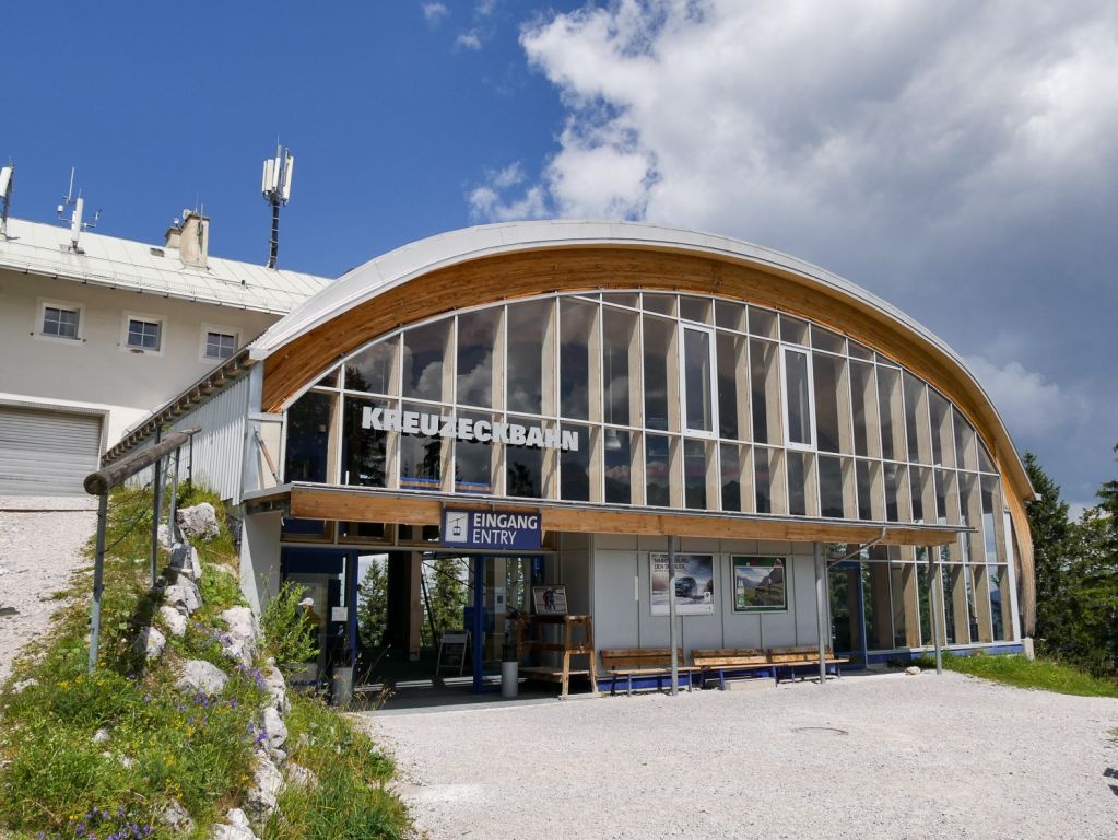 Mit der Kreuzeckbahn aufs Garmischer Kreuzeck - Die Kreuzeckbahn ist die älteste Bahn in Garmisch-Partenkirchen. Nein - natürlich nicht diese Version hier, denn die stammt aus dem Jahr 2002. Den Vorgänger allerdings gab es mit ein paar Umbauten seit dem Jahr 1926, in dem die Kreuzeckbahn als erste Seilschwebebahn in Bayern ihren Betrieb aufnahm. Die Kapazität von anfangs sogar nur 150 Personen in der Stunde reichte natürlich nie und so wurde nach zahlreichen Umbauten und den begrenzt möglichen Erweiterungen der Kapazität im Winter 2002 die heutige Anlage mit einer Förderleistung von 2.000 Personen pro Stunde in Betrieb genommen.

Die Bahn ist auch im Sommer extrem beliebt und führt auf etwa 1.600 Meter Seehöhe. Von dort geht es unter anderem auf einem Fahrweg weiter zur Hochalm, wo sich die nächste Seilbahn anschließt. - © alpintreff.de