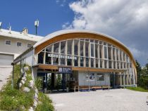 Mit der Kreuzeckbahn aufs Garmischer Kreuzeck - Die Kreuzeckbahn ist die älteste Bahn in Garmisch-Partenkirchen. Nein - natürlich nicht diese Version hier, denn die stammt aus dem Jahr 2002. Den Vorgänger allerdings gab es mit ein paar Umbauten seit dem Jahr 1926, in dem die Kreuzeckbahn als erste Seilschwebebahn in Bayern ihren Betrieb aufnahm. Die Kapazität von anfangs sogar nur 150 Personen in der Stunde reichte natürlich nie und so wurde nach zahlreichen Umbauten und den begrenzt möglichen Erweiterungen der Kapazität im Winter 2002 die heutige Anlage mit einer Förderleistung von 2.000 Personen pro Stunde in Betrieb genommen.

Die Bahn ist auch im Sommer extrem beliebt und führt auf etwa 1.600 Meter Seehöhe. Von dort geht es unter anderem auf einem Fahrweg weiter zur Hochalm, wo sich die nächste Seilbahn anschließt. • © alpintreff.de